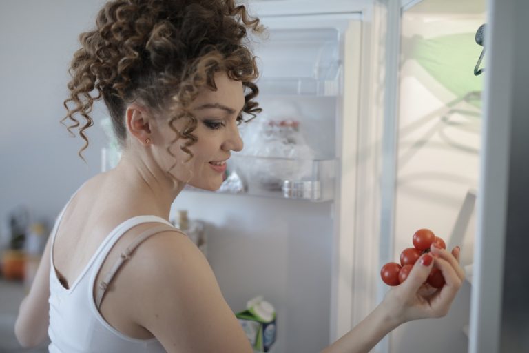 a woman holding a red fruit